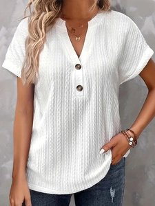 Close-up of white V-neck T-shirt showing vertical textured fabric and wooden button details