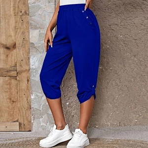 Detail of bright blue cropped summer trousers with elastic waist and side metal buttons