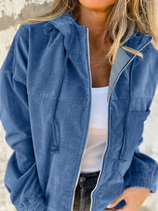 Close-up of dark blue corduroy hooded jacket showing metal zipper and fabric texture