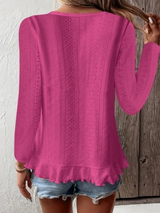 Détail d'un haut rose fuchsia à manches longues avec broderie anglaise et ourlet volanté