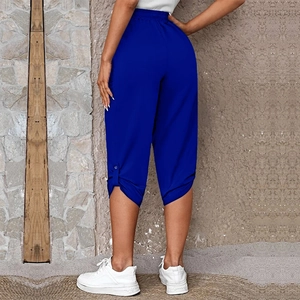 Detail of royal blue capris with elastic high waist and side button slit on leg hem