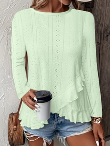 Détail du haut vert clair brodé à œillets avec ourlet à volants et tissu texturé chic