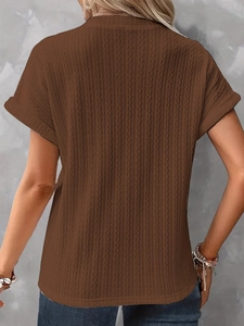 Close-up of brown knit top featuring vertical cable texture and rolled sleeve details