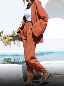 Détail d'un ensemble deux pièces en coton et lin orange avec gilet ample et pantalon taille haute