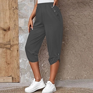 Detail view of dark grey cropped pants with elastic waist and metal side buttons