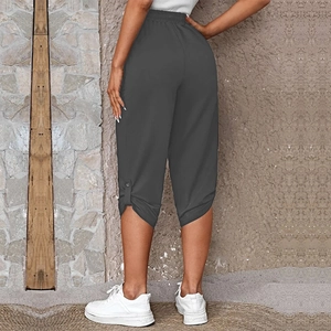 Close-up of summer capri pants featuring elastic waistband and buttoned side slit hem