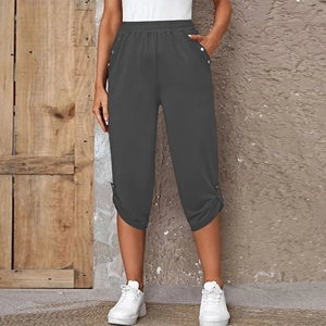 Detail of elastic waistband and decorative buttons on dark gray cropped summer trousers