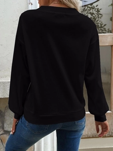 Details des schwarzen Waffelstrick-Sweatshirts mit überschnittenen Schultern und Rippbündchen