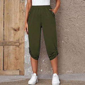 Detail of army green cropped pants with decorative side buttons and elastic waistband