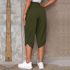 Detail of olive green cropped pants featuring elastic waist and decorative buttoned cuffs