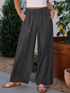 Detailed view of dark grey wide-leg pants with elastic pleated waist and large patch pockets