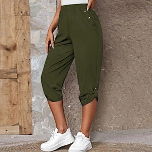 Detail of dark green capri pants with elastic waist and side button slit design