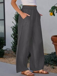 Detail of high waist elastic waistband and large pockets on wide leg trousers