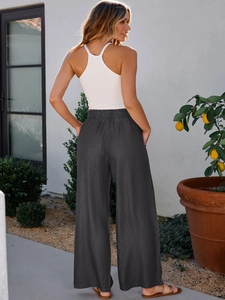 Detail of high waisted wide leg dark grey trousers with elastic waistband and side pockets