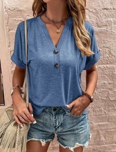 Detail of grey-blue short sleeve top featuring V-neckline with decorative buttons