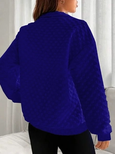 Detail of dark blue knit sweatshirt featuring 3D bubble texture and ribbed cuffs