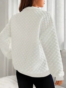 Detail of white long sleeve sweatshirt with unique waffle knit texture and zipper design