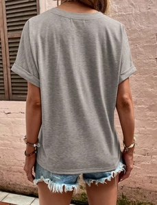 Detail of rolled sleeve cuffs on a grey knit t-shirt with raw hem denim shorts