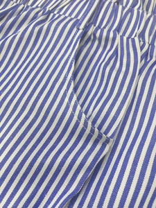 Detail der blau-weiß vertikal gestreiften Shorts mit Gummibund und seitlichen Taschen