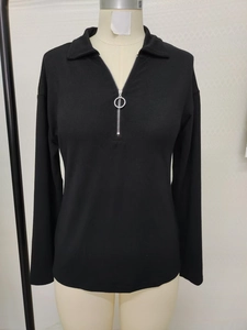 Detail of black ribbed polo shirt featuring a functional silver ring zipper and collar
