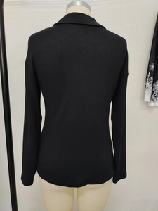 Detail view of the black ribbed knit fabric and back collar design on a long sleeve top