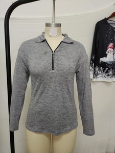 Detail of grey long sleeve polo knit top with silver ring zipper and collar