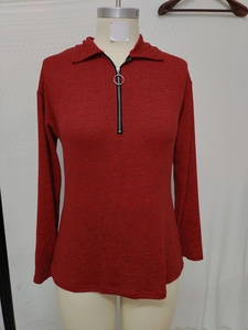 Detail of red textured knit polo top with half-zip closure and stylish circular puller