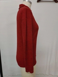 Detail of red mock-neck knit sweater showing textured fabric and casual drop-shoulder design