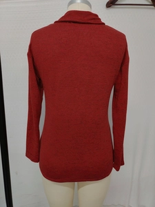 Detail view of the back of a dark red long-sleeved knitted sweater with textured fabric