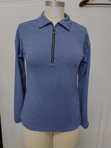 Detail of dark blue knit polo shirt featuring lapel collar and silver ring zipper pull