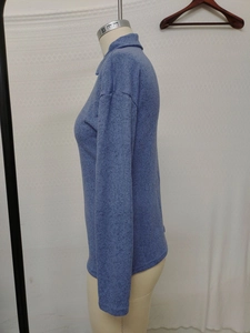 Detail of blue marled knit fabric and lapel collar zip on casual long sleeve top