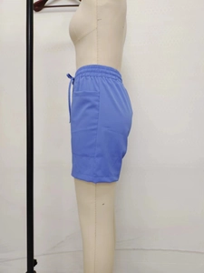 Detail of light blue linen shorts featuring elastic drawstring waist and large side pocket