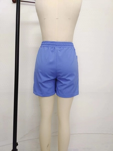 Detail view of the back of blue linen-style loose shorts with elastic high waist