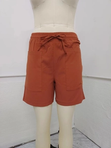 Detail of high waist linen shorts with drawstring waist and large side patch pockets