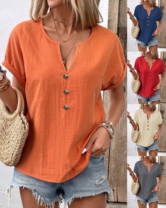 Detail of V-neck cotton linen shirt with vintage buttons and folded sleeves for women