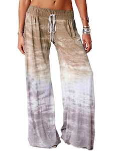 Dettaglio dei pantaloni da yoga larghi con sfumatura marrone, tie-dye e coulisse in vita