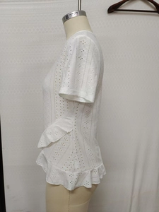 Detail of white eyelet short sleeve t-shirt with ruffled hem on a dress form