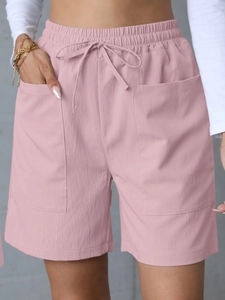 Close-up of pink linen high-waisted shorts featuring a drawstring waist and large cargo pockets