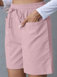 Detail of pink linen casual shorts showing elastic waistband, drawstring and utility pockets