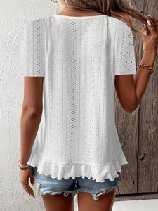 Detail view of white eyelet lace short sleeve top featuring ruffle hem and openwork texture