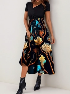 Close-up of elegant patchwork dress showing black V-neck top and artistic floral patterns