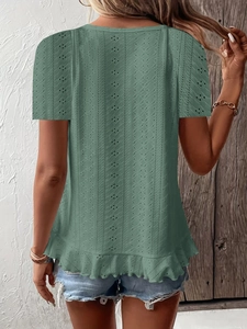 Detail of dark green eyelet embroidery texture and ruffle hem on women's short sleeve top