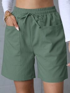 Detail of high waist linen shorts with drawstring elastic waist and side pockets
