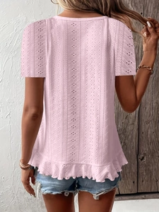 Detail of pink eyelet short sleeve top with ruffle hem and textured hollow fabric