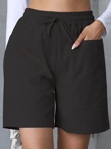 Detail shot of women's black linen shorts featuring elastic drawstring waist and large pockets