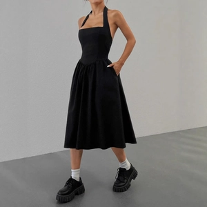 Détail d'une robe noire dos nu ajustée avec des poches latérales et une jupe évasée