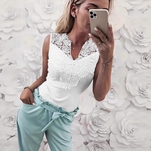 Close-up of white V-neck lace trim tank top paired with green bow-tie wide-leg pants