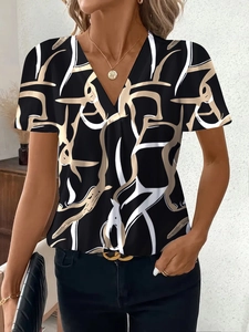 Dettaglio del top con scollo a V con stampa astratta moderna e collana dorata