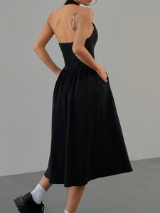 Robe midi moulante dos nu à licou noir uni avec poches latérales pratiques