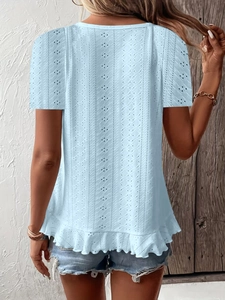 Detail view of light blue eyelet embroidery fabric with tiered ruffle hem on t-shirt back